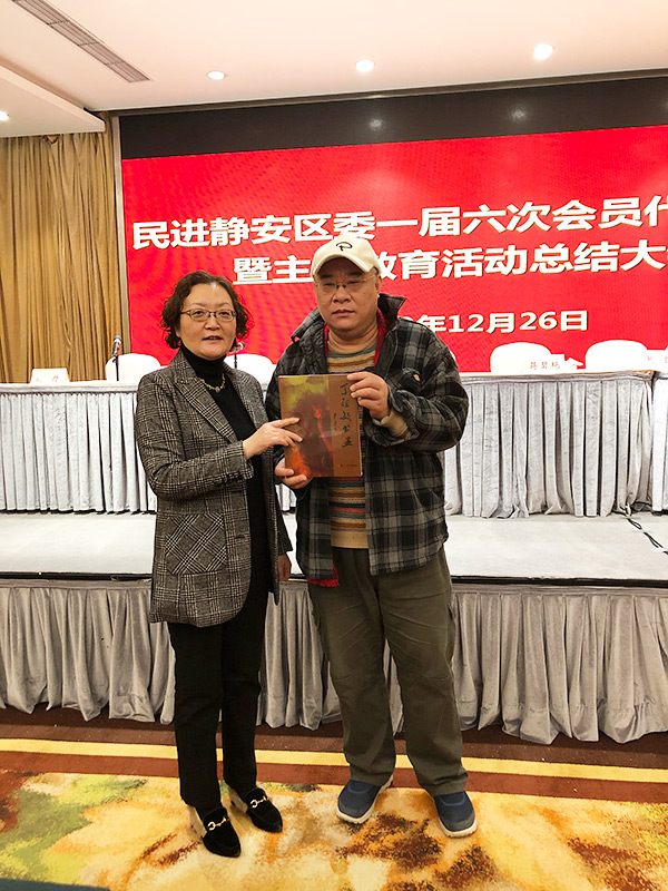 丁祖敏（右）向贵州贫困山区学校捐赠新著《丁祖敏书画》