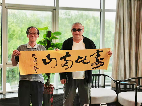 丁祖敏（右）书赠老教师《寿比南山》横幅