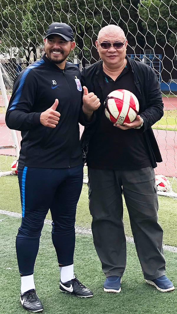 丁祖敏（右）与巴西足球教练交流球艺